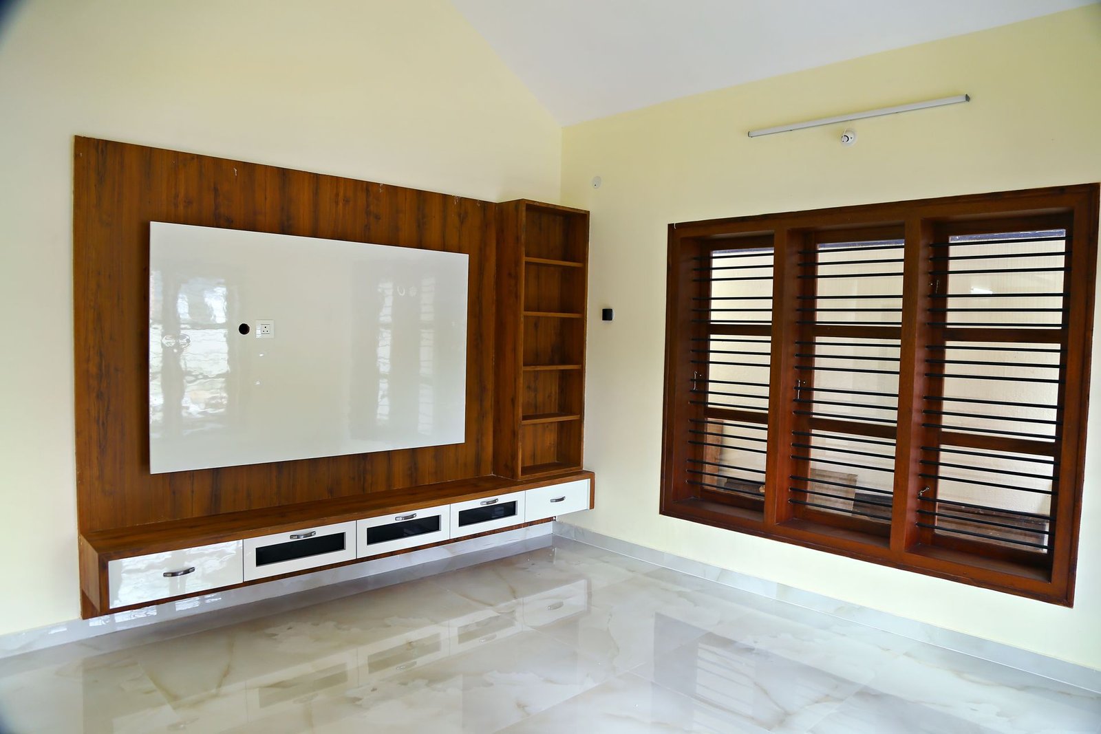 Wall-mounted TV unit with wooden panelling and teak window in a Matrix Realty home